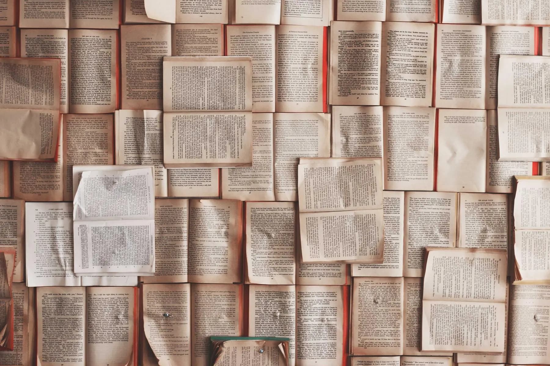 A wall covered edge to edge with open book pages.